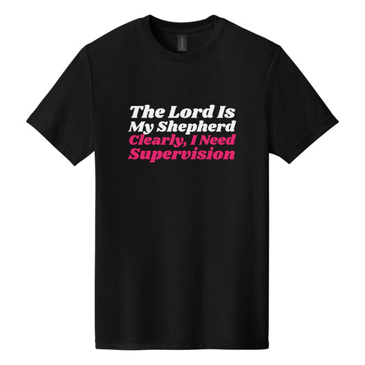 The Lord Is My Shepherd. Clearly, I Need Supervision tee in Pitch Black, Shrikhand font, White + Hot Pink ink